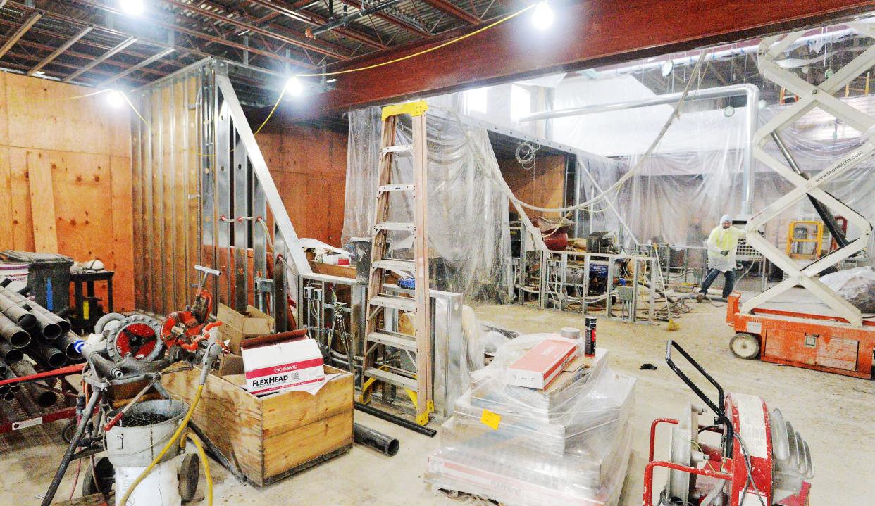 Fire retardant is sprayed near four golf simulators, from near left to back center, at a new Five Iron Golf location under construction in Erie on Feb. 8, 2024.