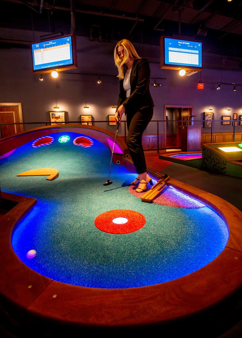 Lauren Nelson, brand communications specialist at Puttshack, gets in a practice shot on one of the holes, Feb. 7, 2024. Puttshack opens to the public on Saturday. Each round on any of the three nine-hole courses runs $18 for adults and $10 for children 12 and under.