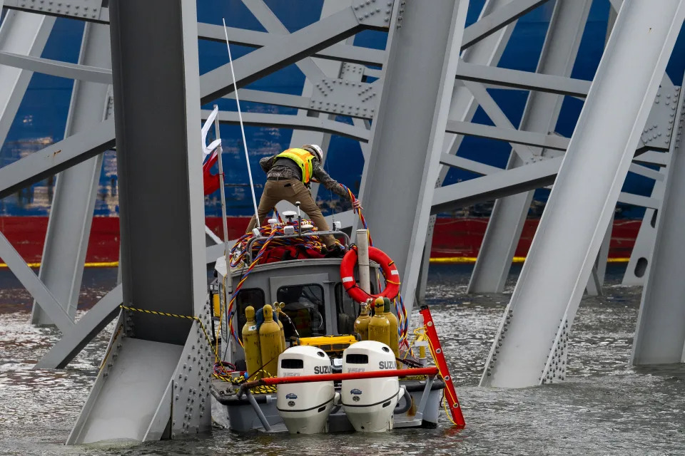 Un membro dell'equipaggio su una piccola imbarcazione lavora vicino all'operazione di salvataggio del ponte Francis Scott Key crollato, a Sparrows Point, Maryland, il 30 marzo 2024. (Pete Kiehart/The New York Times)