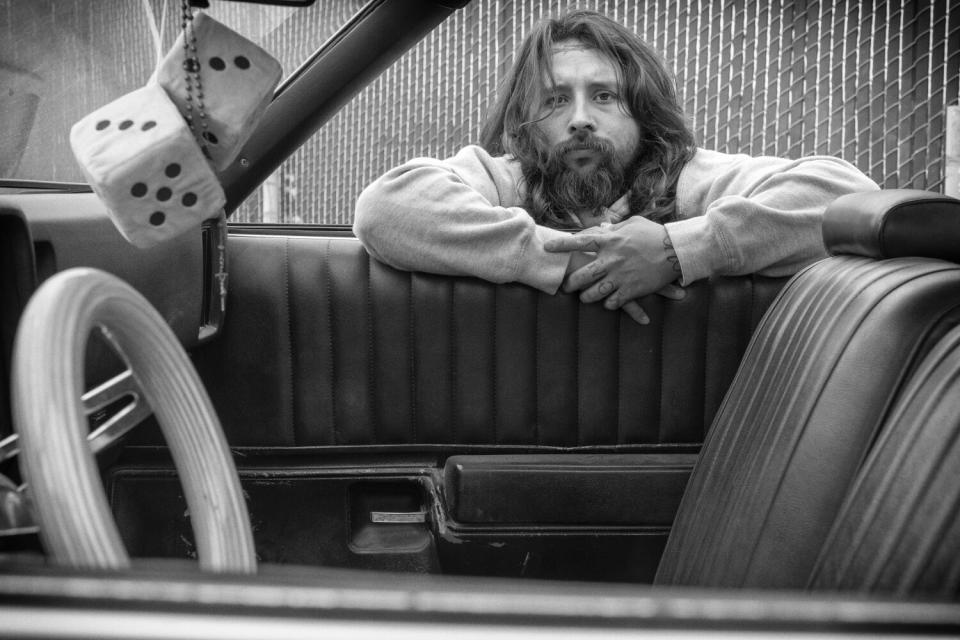 Mark Hocutt looking at the viewer through a window of his '73 Chevy El Camino, "Electric Funeral"