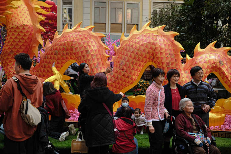 People take photos in a shopping area in front of a dragon during Lunar New Year. The city celebrates first Lunar New Year since pandemic restrictions ended. Keith Tsuji/ZUMA Press Wire/dpa