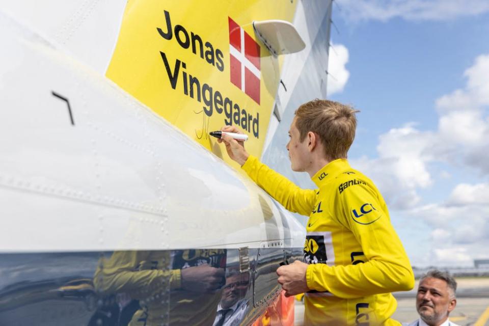 Jonas Vingegaard signs the tail of the private plan he flew home on