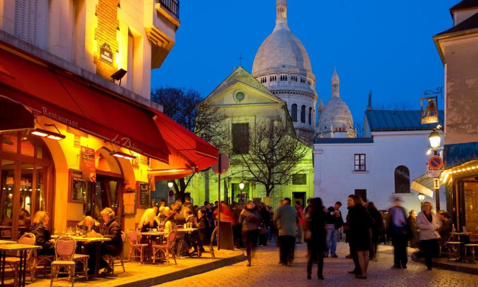 A late night scene in Montmatre, Paris, with a restaurant in the foreground