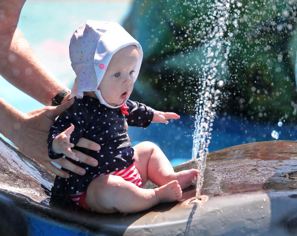 Joanna Burkett gets acclimated to watery fun at the splash pad at Veterans Park in Plain Township. The 6-month-old is held by her father Trevor Burkett. Also along for the summer outing was Joanna's mother Ali Burkett and her grandmother Janie Murphy.