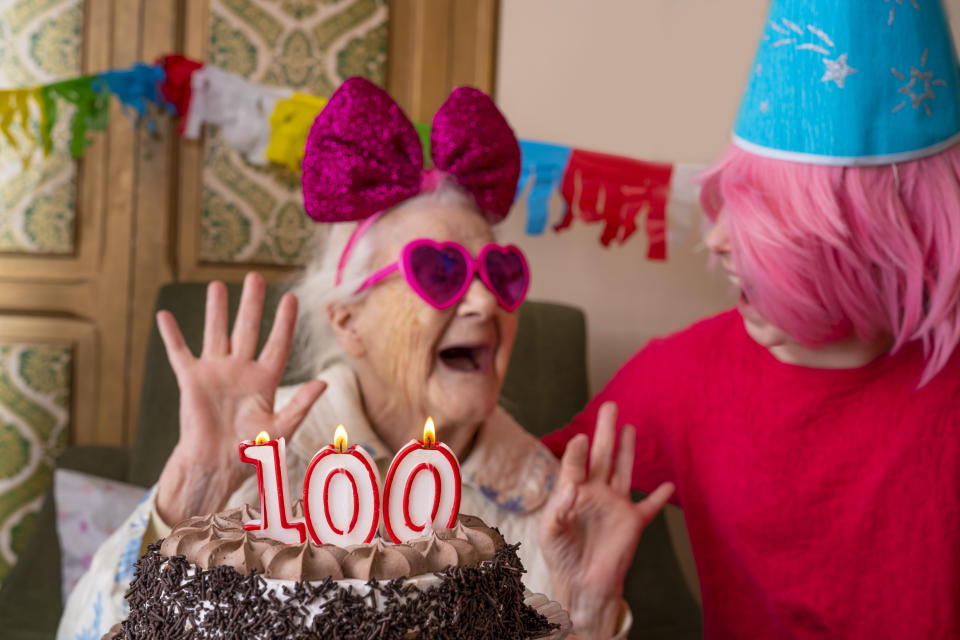 100 years old birthday cake to old woman elderly celebration with granddaughter pension