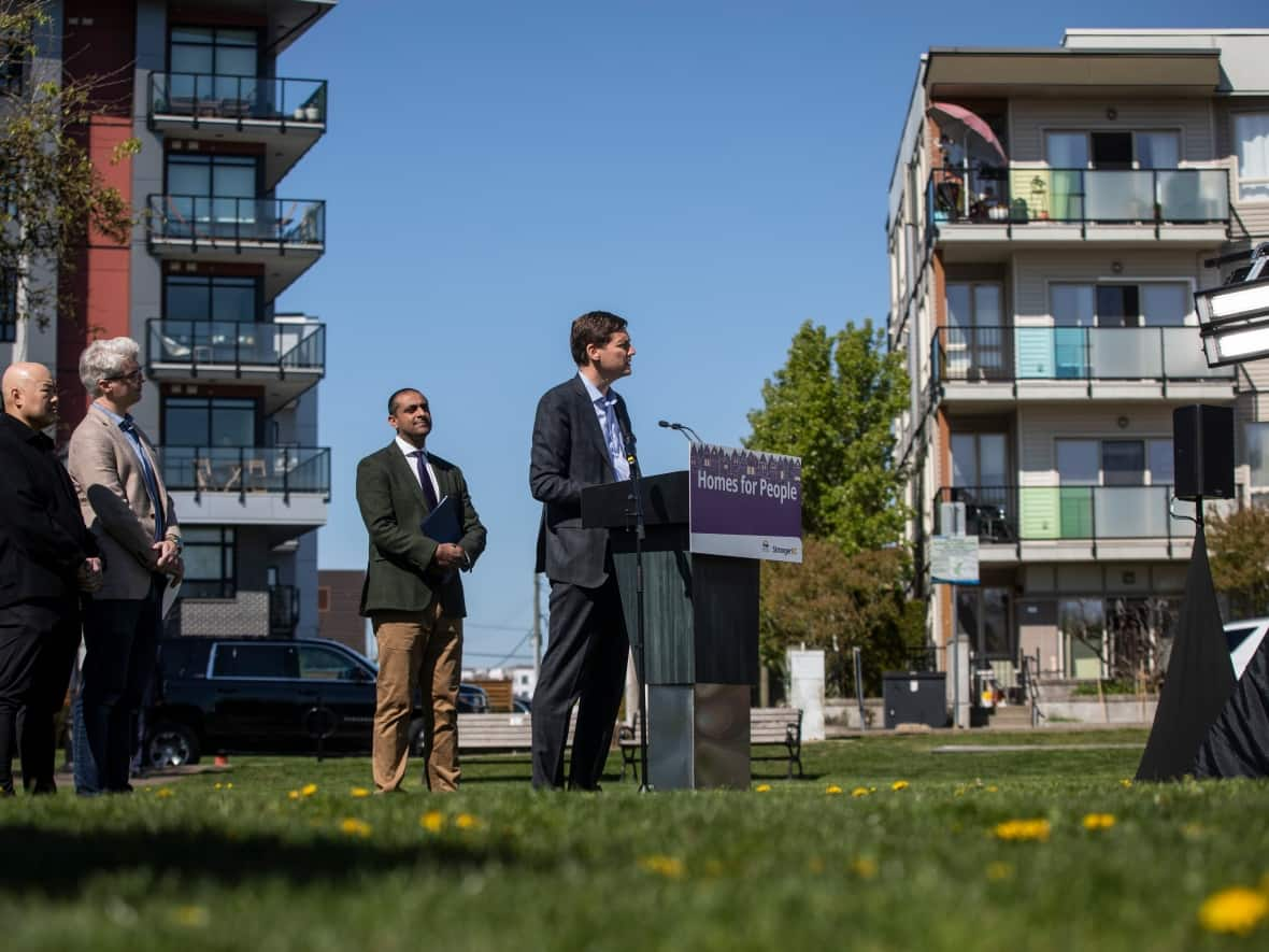 Premier David Eby speaks at a news conference in Langley, B.C., regarding short-term rental restrictions on Thursday. Housing Minister Ravi Kahlon looks on. (Ben Nelms/CBC - image credit)