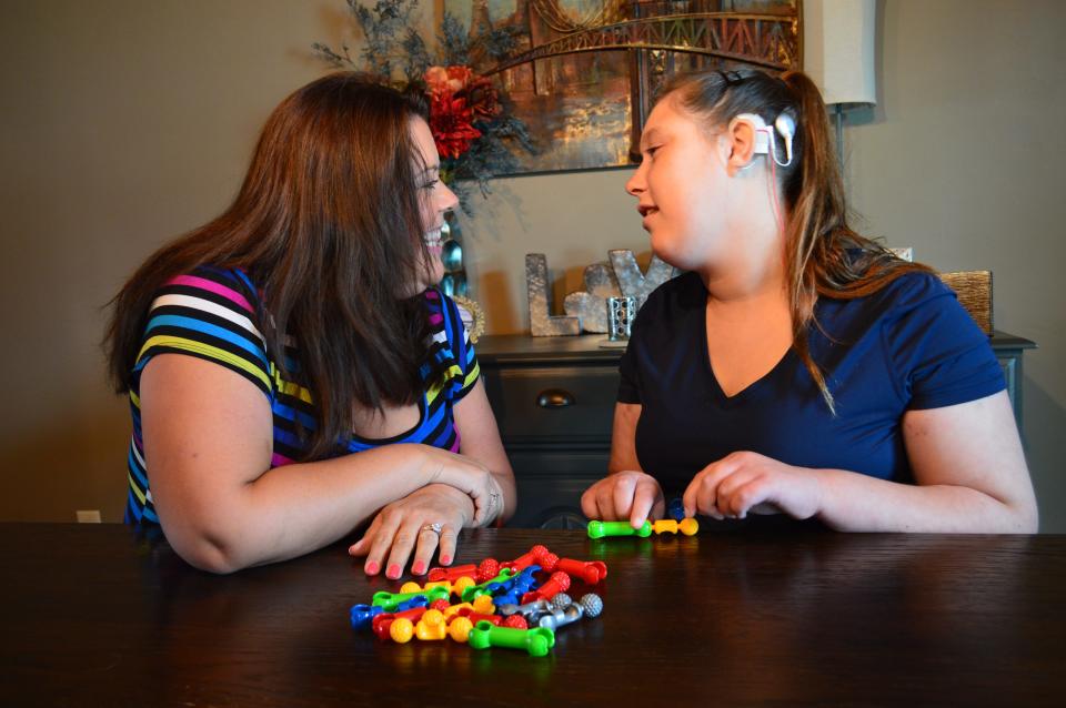 Ainsley Webb, who is deaf and non-verbal autistic, plays with her mother, Heather Schmid, in their De Pere home on Aug. 20, 2022.