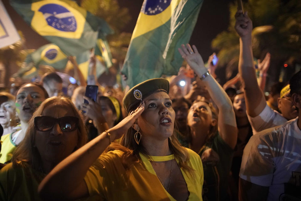 Una simpatizante de Jair Bolsonaro saluda durante la celebración de su triunfo en las elecciones presidenciales afuera de la residencia del candidato en Río de Janeiro, Brasil, el 28 de octubre de 2018. (AP Foto/Leo Correa)