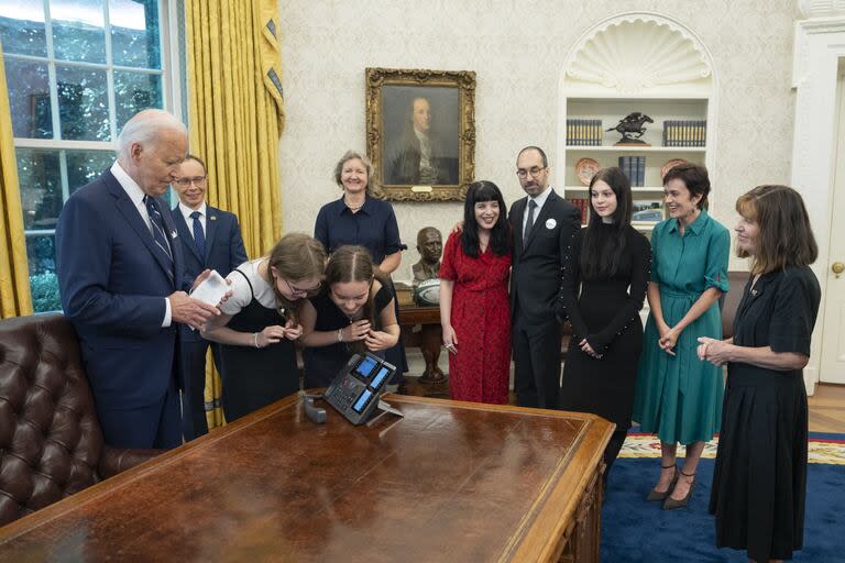 El presidente de Estados Unidos, Joe Biden, con familiares de prisioneros, observa cómo las hermanas Miriam y Bibi Butorin hablan con su madre, la periodista prisionera liberada Alsu Kurmasheva, en el Salón Oval de la Casa Blanca en Washington, el 1 de agosto de 2024. (Adam Schultz / AFP)