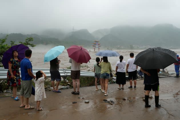 Residents look over an area inundated by flood waters in Miaofengshan on the outskirts of Beijing, August 1, 2023. 