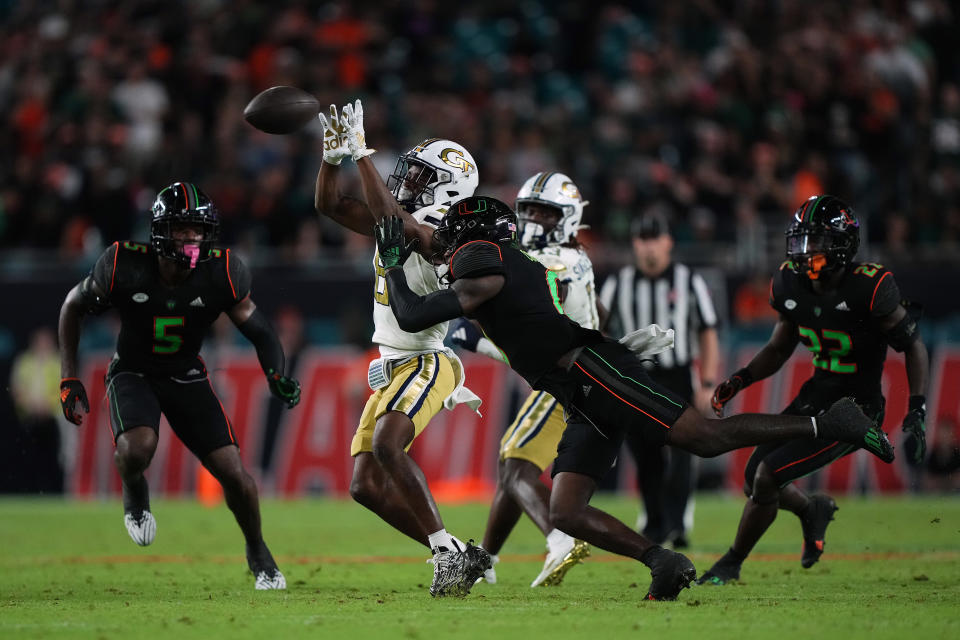 Oct 7, 2023; Miami Gardens, Florida, USA; Miami Hurricanes cornerback Te’Cory Couch (0) attempts to break up the pass to Georgia Tech Yellow Jackets wide receiver Malik Rutherford (8) in the second half at Hard Rock Stadium. Mandatory Credit: Jasen Vinlove-USA TODAY Sports