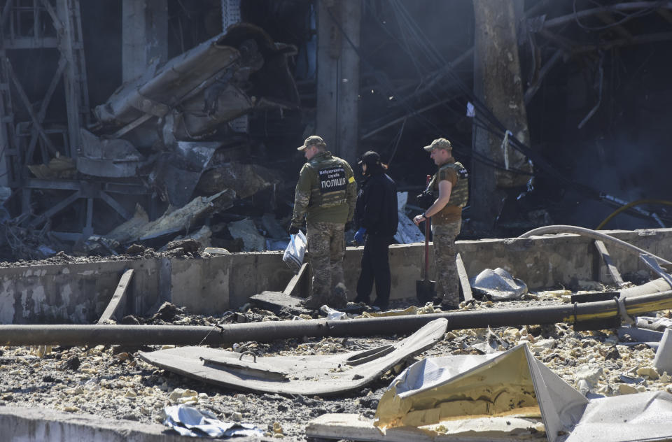 Ukrainian investigators work near a destroyed building on the outskirts of Odesa, Ukraine, Tuesday, May 10, 2022. The Ukrainian military said Russian forces fired seven missiles a day earlier from the air at the crucial Black Sea port of Odesa, hitting a shopping center and a warehouse. (AP Photo/Max Pshybyshevsky)