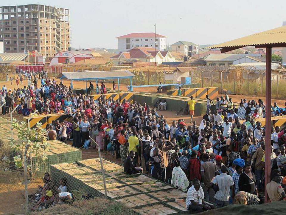 In this handout image provided by the United Nations Mission South Sudan, taken on Tuesday, Dec. 17, 2013, civilians arrive at the UNMISS compound adjacent to Juba International Airport to take refuge.  (AP Photo/UNMISS/Rolla Hinedi)