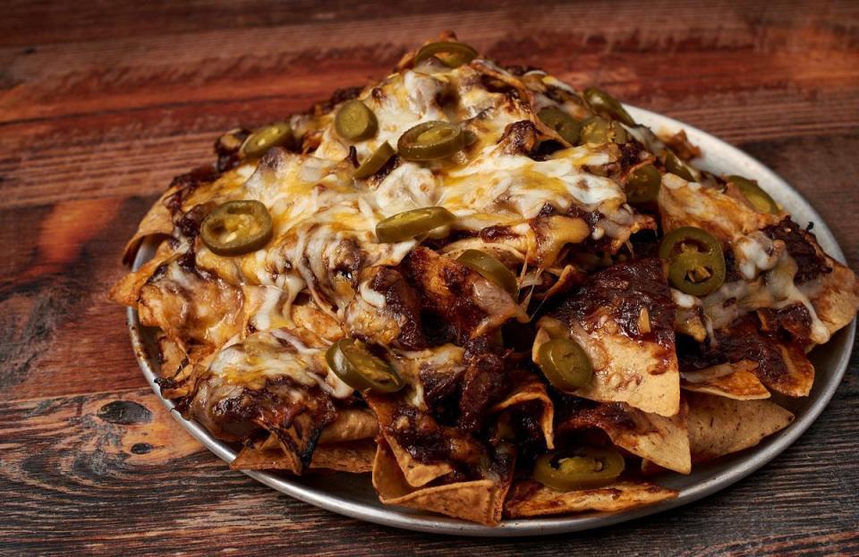 <p>These barbecue nachos call for not one, not two, but <em>three</em> different types of meat. For all of the barbecue lovers at your Fourth of July bash, this dish will be the hero. It’s a <a href="https://www.thedailymeal.com/how-to-use-up-leftovers?referrer=yahoo&category=beauty_food&include_utm=1&utm_medium=referral&utm_source=yahoo&utm_campaign=feed" rel="nofollow noopener" target="_blank" data-ylk="slk:great way to use any leftovers;elm:context_link;itc:0;sec:content-canvas" class="link ">great way to use any leftovers</a> you may have from the previous night’s dinner. Let your kids top the nachos with cheese and jalapeños.</p> <p><a href="https://www.thedailymeal.com/recipes/barbecued-nachos-recipe?referrer=yahoo&category=beauty_food&include_utm=1&utm_medium=referral&utm_source=yahoo&utm_campaign=feed" rel="nofollow noopener" target="_blank" data-ylk="slk:For the Outrageous Barbecued Nachos recipe, click here;elm:context_link;itc:0;sec:content-canvas" class="link ">For the Outrageous Barbecued Nachos recipe, click here</a>.</p>