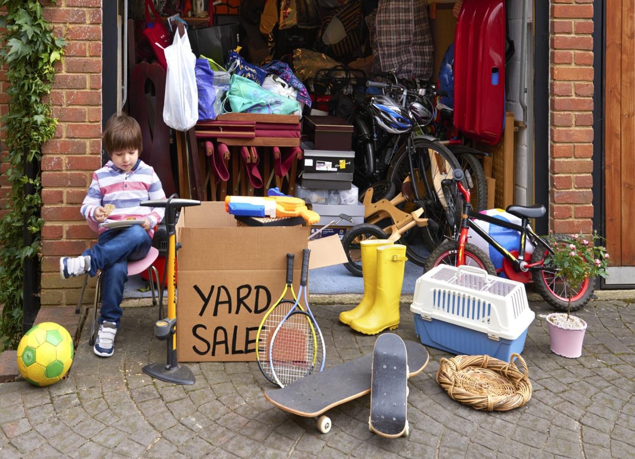 child sitting outside for yard sale