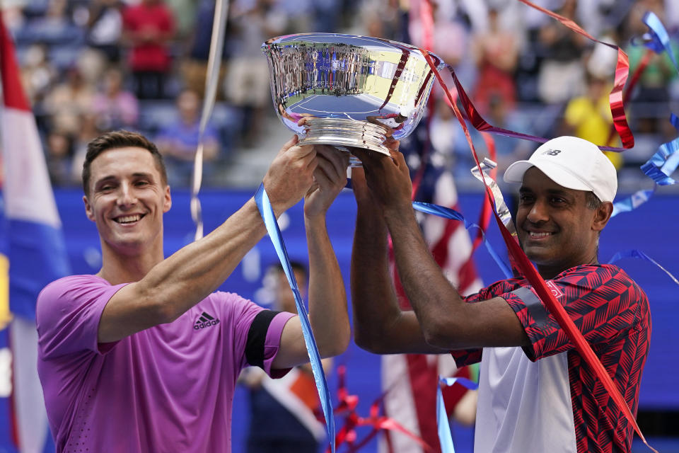 Rajeev Ram, of the United States, right, and Joe Salisbury, of Britain, celebrate with the trophy after defeating Wesley Koolhof, of the Netherlands, and Neal Skupski, of Britain, in the final of the men's doubles at the the U.S. Open tennis championships, Friday, Sept. 9, 2022, in New York.(AP Photo/Charles Krupa)