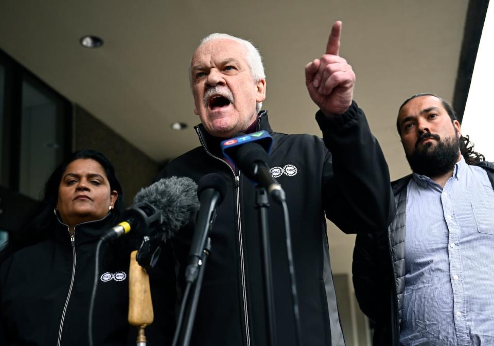 Chris Aylward, national president of the Public Service Alliance of Canada (PSAC), speaks with vice-presidents Sharon DeSousa, left, and Alex Silas on April 22, 2023 in Ottawa.