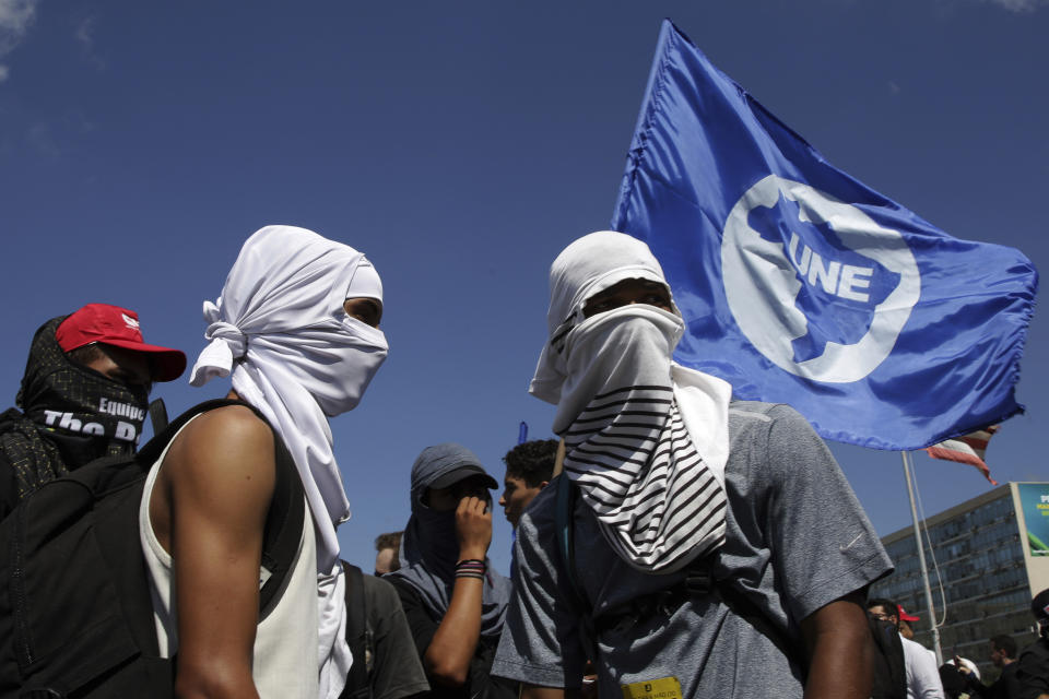 Masked students take part in a nation-wide education strike, in Brasilia, Brazil, Wednesday, May 15, 2019. Federal education officials this month announced budget cuts of $1.85 billion for public education, part of a wider government effort to slash spending. (AP Photo/Eraldo Peres)