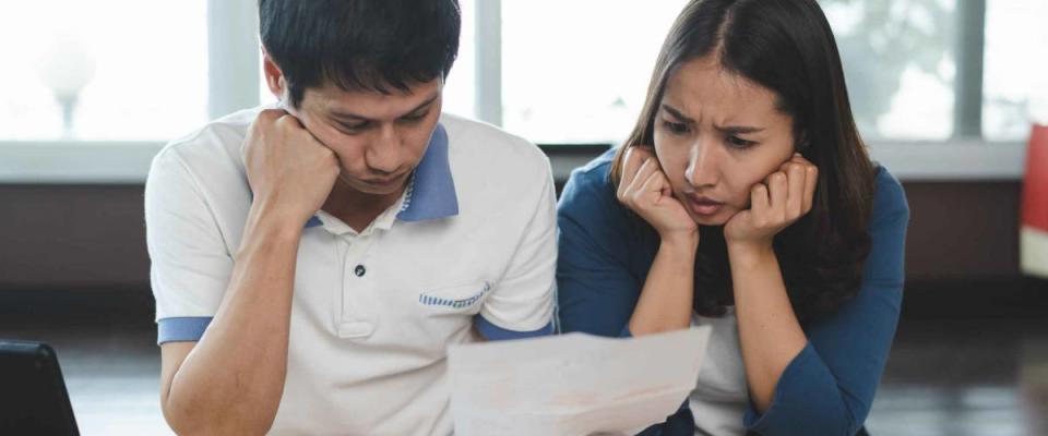 Family financial crisis concept. Stressed couple calculating credit card debt.