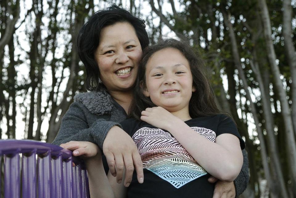 Joyce Chen hugs her daughter Kathryn, 10, as they pose for photographs in San Francisco, Wednesday, May 29, 2013. A new poll finds that one in five unmarried women would consider having a child on their own, and more than a third would consider adopting solo, just one indication of America’s changing family structures. (AP Photo/Jeff Chiu)