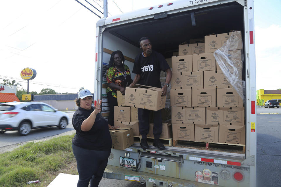 FILE - Brittany Martin, center, passes out food boxes with her group Mixed Sistaz United, in Sumter, S.C., in May 2021. Martin, a pregnant Black activist serving four years in prison over comments she made to police during racial justice protests in the summer of 2020, will not receive a lesser sentence, a judge has ruled. (Shelbie Goulding/The Item via AP, File)