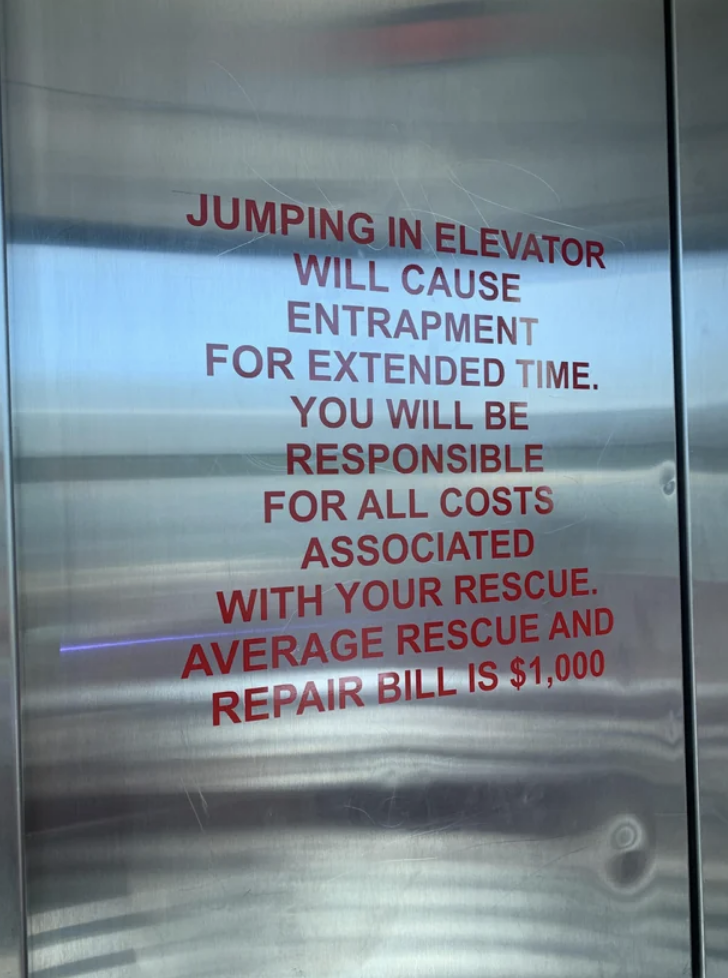 A message on an elevator door reads "jumping in elevator will cause entrapment for extended time. You will be responsible for all costs associated with your rescue"