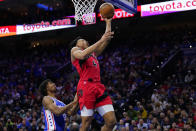 Toronto Raptors' Scottie Barnes, right, goes up for a shot past Philadelphia 76ers' Tyrese Maxey during the first half of Game 5 in an NBA basketball first-round playoff series, Monday, April 25, 2022, in Philadelphia. (AP Photo/Matt Slocum)