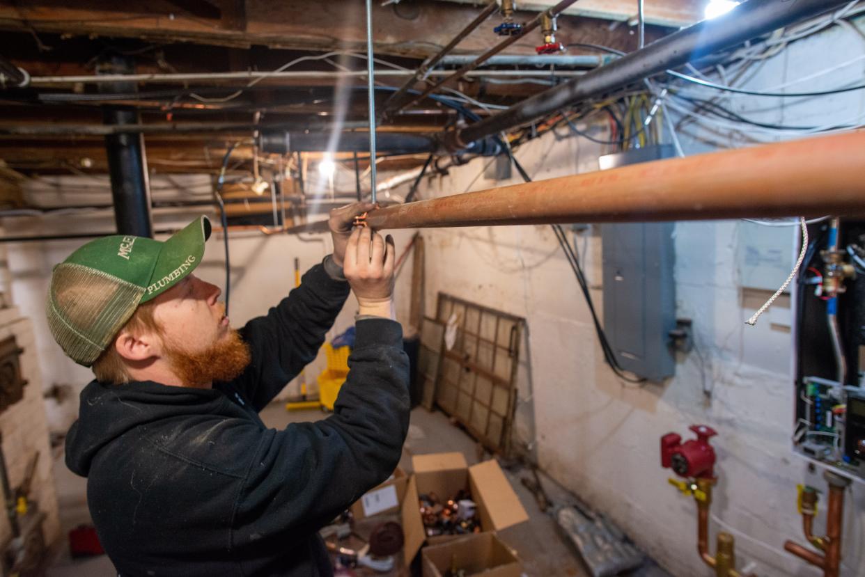 McElroy's HVAC technician Wyatt Lickteig adds a new piece of copper pipe as part of the instillation of a new Navien system to replace a boiler in the basement of a Topeka residence Friday afternoon.