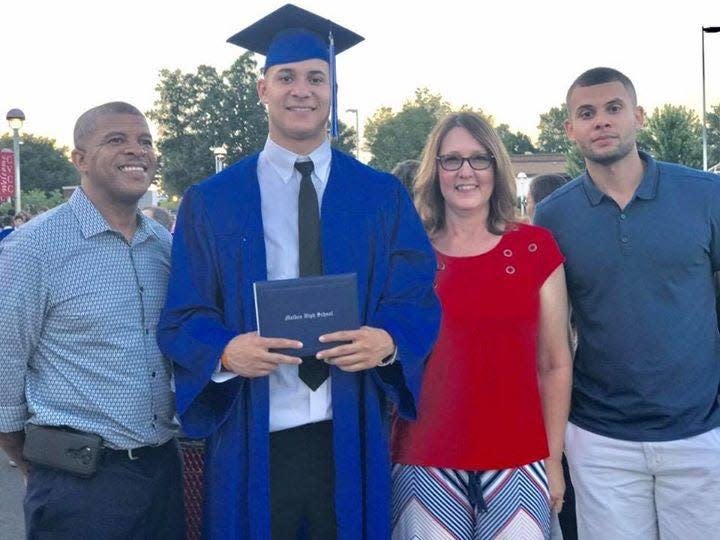 Caleb Farley stands with his cap, gown and diploma surrounded by his father, Robert (left), mother Robin and brother Joshua (right) during Caleb's high school graduation in Maiden, North Carolina in 2017. The Tennessee Titans selected the Virginia Tech cornerback in the first round (22nd pick) of the 2021 NFL Draft Thursday, April 27.