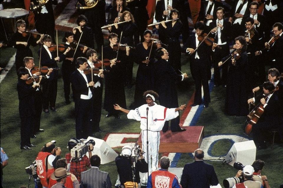 Whitney Houston singing on the football field with orchestra