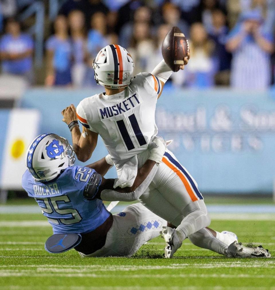 Virginia quarterback Tony Musket (11) is stopped by North Carolina’s Kaimon Rucker (25) in the first quarter on Saturday, October 21, 2023 at Kenan Stadium in Chapel Hill, N.C. Musket was called for intentional grounding.