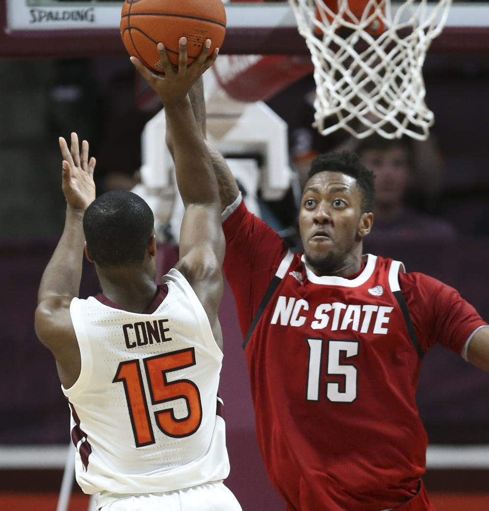 Virginia Tech's Jalen Cone (15) has his shot blocked by North Carolina State's Manny Bates (15) in the first half of an NCAA college basketball game Saturday, Jan. 11, 2020, in Blacksburg, Va. (Matt Gentry/The Roanoke Times via AP)