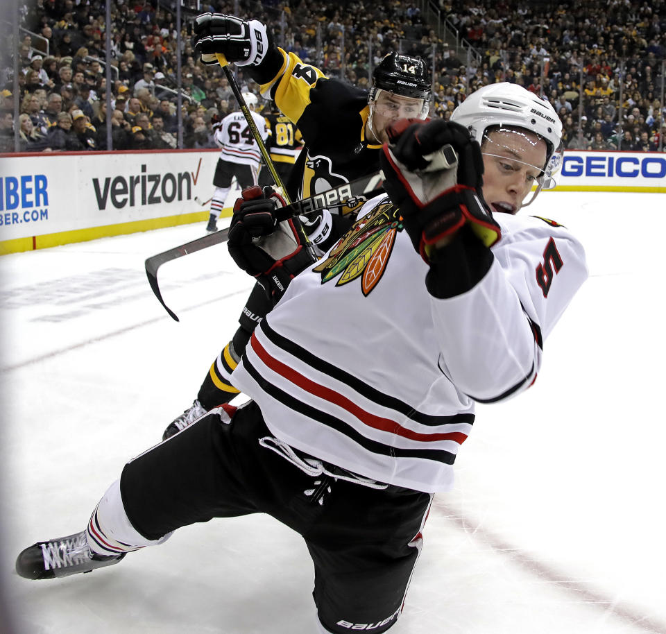Chicago Blackhawks' Connor Murphy (5) is tripped by Pittsburgh Penguins' Tanner Pearson (14) during the second period of an NHL hockey game in Pittsburgh, Sunday, Jan. 6, 2019. (AP Photo/Gene J. Puskar)