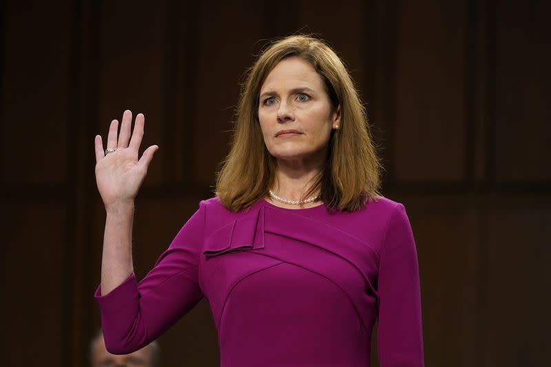 La candidata a la Corte Suprema de Estados Unidos Amy Coney Barrett presta juramento durante su audiencia de confirmación ante el Comité Judicial del Senado con su familia en el Capitolio de Washington.