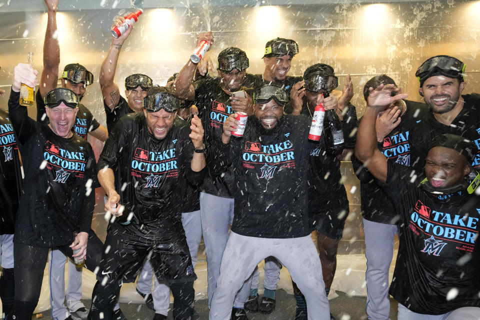 The Miami Marlins celebrate in the locker room after clinching a playoff berth with a win over the Pittsburgh Pirates in a baseball game in Pittsburgh, Saturday, Sept. 30, 2023. (AP Photo/Gene J. Puskar)