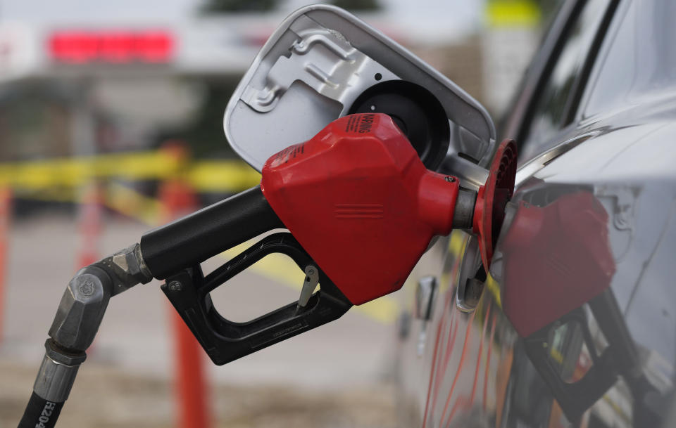 FILE - A motorist fills up the tank on a sedan, on July 22, 2022, in Saratoga, Wyo. Falling gas prices gave Americans a slight break from the pain of high inflation last month, though the surge in overall prices slowed only modestly from the four-decade high it reached in June.  (AP Photo/David Zalubowski, File)