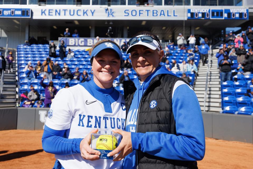 Kentucky senior Erin Coffel shows off her program record home run ball with coach Rachel Lawson
