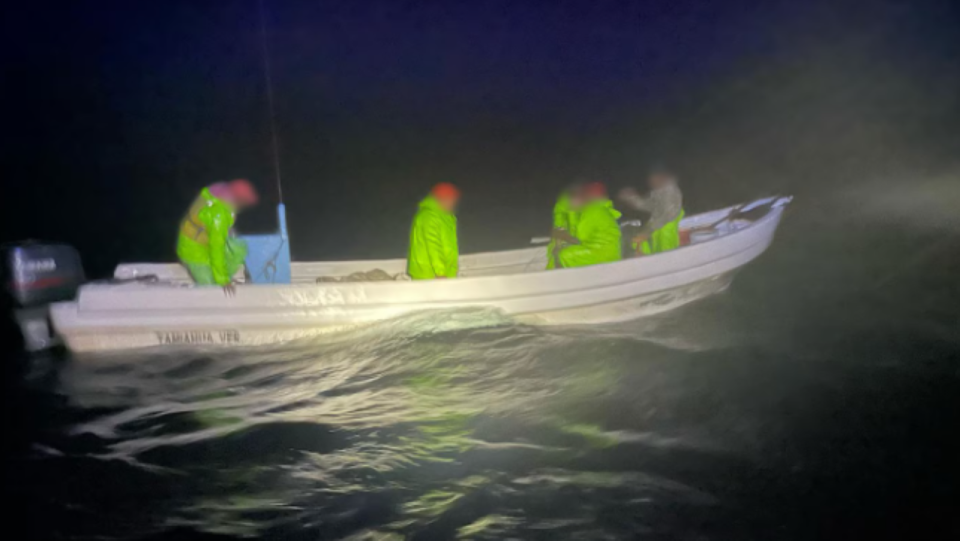 Wide shot of men standing on boat in water