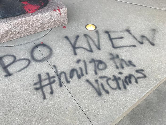 &quot;Bo knew. #hailtothevictims,&quot;is spray painted in front of the Bo Schembechler statue in front of the football building on the University of Michigan campus in Ann Arbor Wednesday, Nov. 24, 2021.