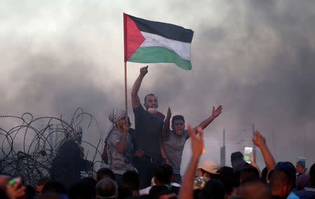 Palestinians shout slogans during a protest calling for lifting the Israeli blockade on Gaza and demanding the right to return to their homeland, at the Israel-Gaza border fence, in the southern Gaza Strip September 21, 2018. REUTERS/Ibraheem Abu Mustafa