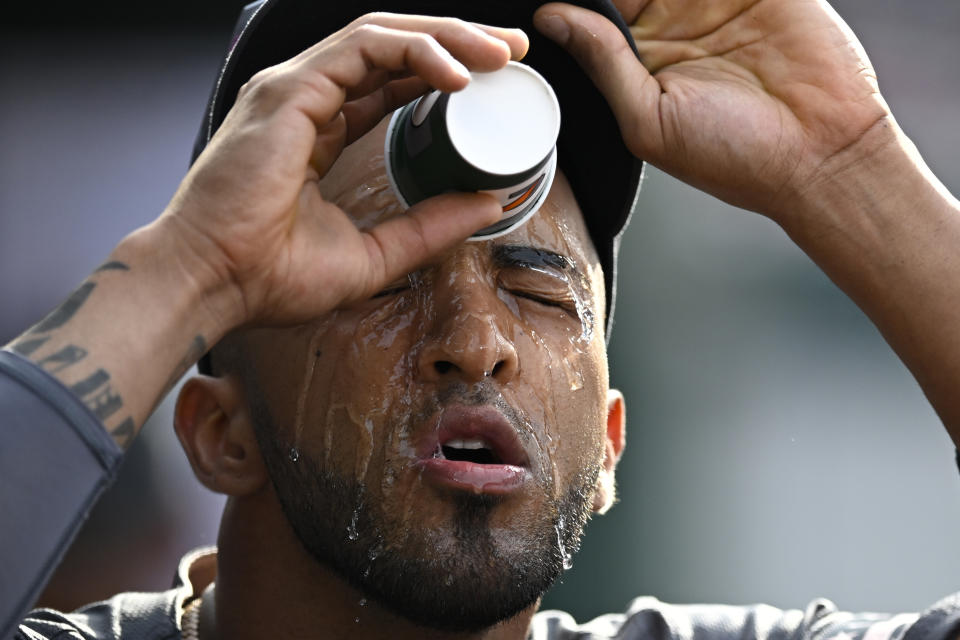 Washington Nationals' Eddie Rosario cools off with water in the dugout during the sixth inning of a baseball game against the Seattle Mariners, Saturday, May 25, 2024, in Washington. (AP Photo/John McDonnell)