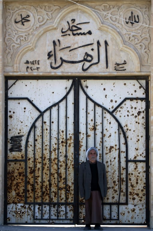 An Iraqi Shabak man at the door of a mosque destroyed by the Islamic State group in the village of Baz Gerkan