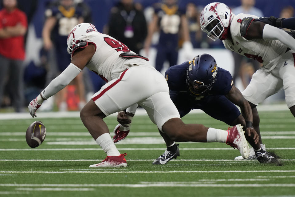 Miami (Ohio) defensive lineman Kobe Hilton (96) recovers the fumble by Toledo quarterback Dequan Finn, center, during the first half of the Mid-American Conference championship NCAA college football game, Saturday, Dec. 2, 2023, in Detroit. (AP Photo/Carlos Osorio)