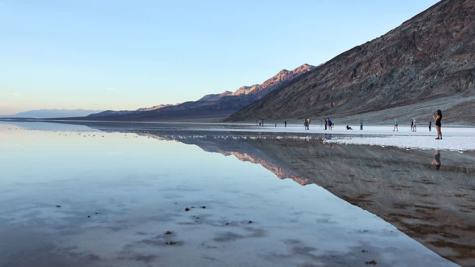 Visitors gather at the sprawling temporary lake at Badwater Basin salt flats at the recently reopened Death Valley National Park on October 21, 2023. - Mario Tama/Getty Images