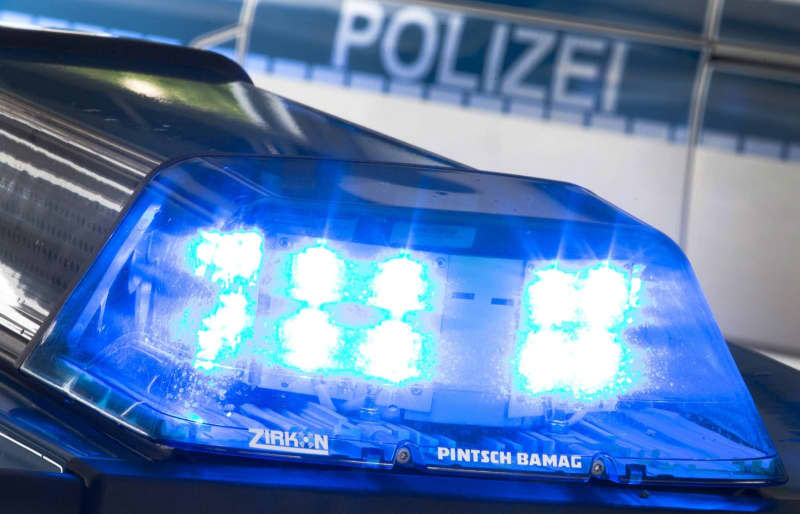 A blue light shines on the roof of a police car. German authorities have again raided the offices of Deutsche Bank wealth management subsidiary DWS as part of an ongoing investigation into allegations of so-called greenwashing. Friso Gentsch/dpa