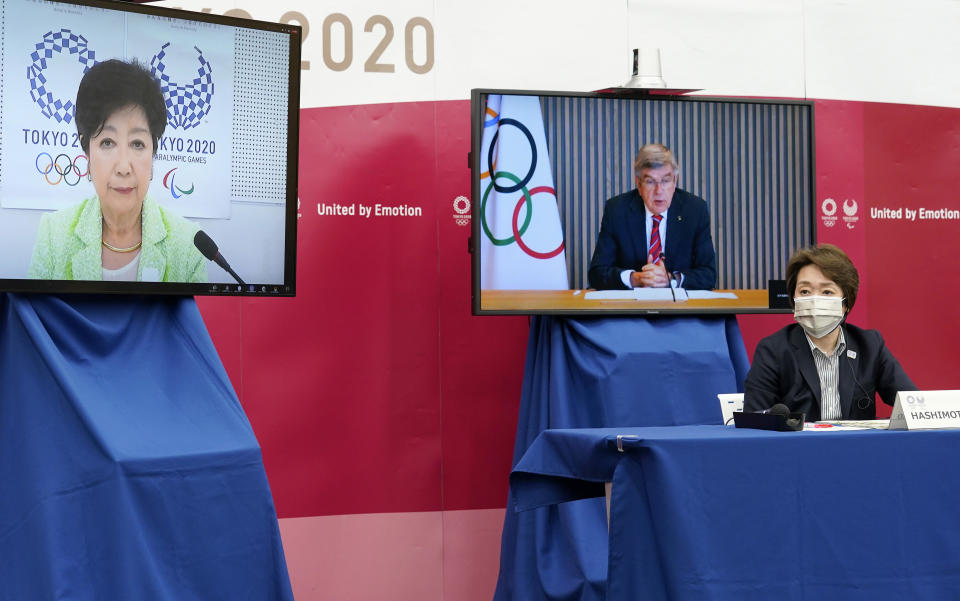 International Olympic Committee president Thomas Bach (on screen at right) delivers an opening speech while Tokyo 2020 Organising Committee president Seiko Hashimoto (R) and Tokyo Governor Yuriko Koike (L) listen during a meeting on the Tokyo 2020 Olympic and Paralympic Games on April 28, 2021 in Tokyo, Japan. / Credit: FRANCK ROBICHON/POOL/Getty