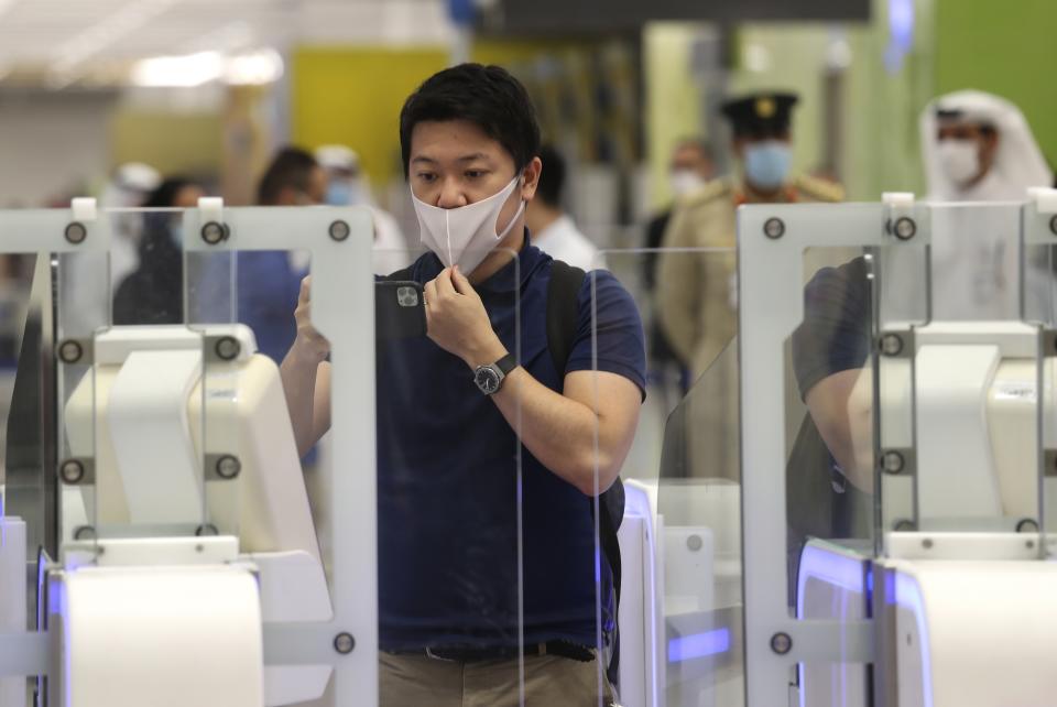 A Japanese journalist checks out the new face and iris-recognition procedures, during a media tour at Dubai airport, United Arab Emirates, Sunday, March 7, 2021. Dubai's airport, the world’s busiest for international travel, has introduced an iris-scanner that verifies one’s identity and eliminates the need for any human interaction when leaving the country. It’s the latest artificial intelligence program the United Arab Emirates has launched amid the surging coronavirus pandemic, technology the government promotes as helping to stem the spread of the virus. (AP Photo/Kamran Jebreili)