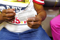 Wilbert Marshall, 71, looks at his shot card after receiving the COVID-19 vaccine at the Aaron E. Henry Community Health Service Center in Clarksdale, Miss., Wednesday, April 7, 2021. Marshall was among a group of seniors from the Rev. S.L.A. Jones Activity Center for the Elderly who received their vaccinations. More Black Americans say they are open to taking the coronavirus vaccine amid campaigns to overcome a shared historical distrust of science and government. (AP Photo/Rogelio V. Solis)