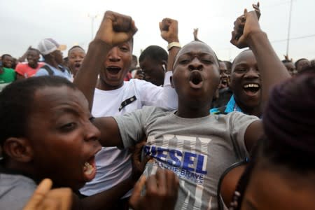 Ibrahim Diakite celebrates with others after Ivory Coast's Wilfried Zaha scored a goal against Mali at the Africa Cup of Nations 2019 (Afcon), while watching the game on screen in Abidjan