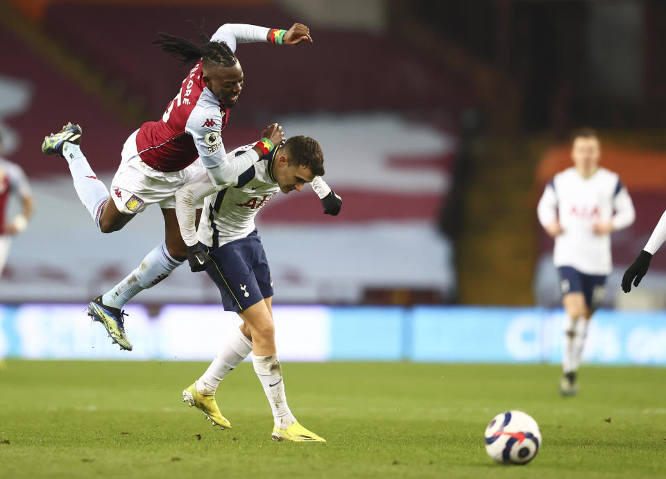 Aston Villa's Bertrand Traore, left, is airborne as he tangles with Tottenham's Sergio Reguilon during the English Premier League soccer match between Aston Villa and Tottenham Hotspur at Villa Park in Birmingham, England, Sunday, March 21, 2021. (AP Photo/Michael Steele,Pool)